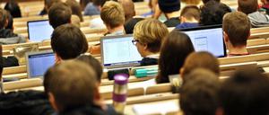 Studierende sitzen im Hörsaal vor ihren Laptops.