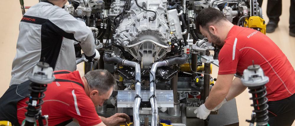Mitarbeiter der Porsche AG montieren im Hauptwerk in Stuttgart den Motor eines Porsche 911.