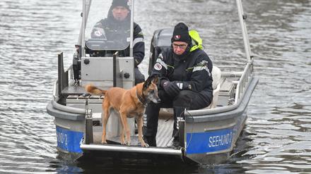 Auf einem Boot suchen Polizeibeamte mit einem Spürhund auf dem Storkower Kanal nahe dem Wolziger See nach Rebecca Reusch.