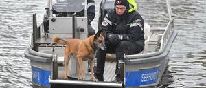 Auf einem Boot suchen Polizeibeamte mit einem Spürhund auf dem Storkower Kanal nahe dem Wolziger See nach Rebecca Reusch.