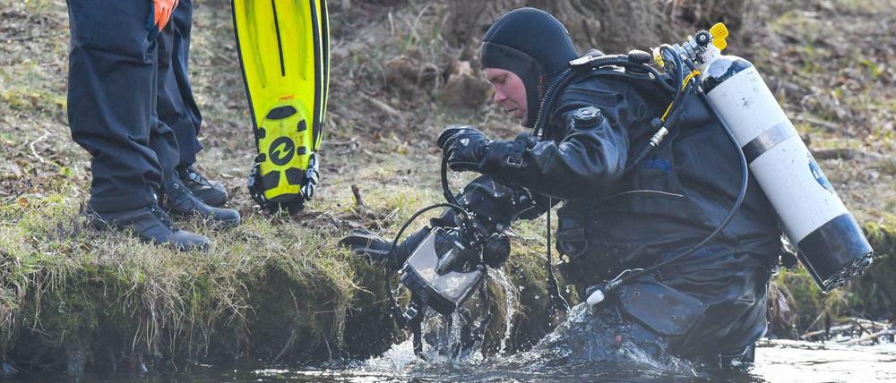 Ein Polizeitaucher kommt aus dem Wasser des Storkower Sees nahe der Mündung in den Wolziger See im Landkreis Dahme-Spreewald.