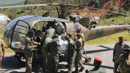 Simbabwe, Chimanimani: Rettungskräfte heben die Leiche eines Opfers in einen Militärhubschrauber.