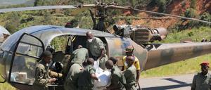 Simbabwe, Chimanimani: Rettungskräfte heben die Leiche eines Opfers in einen Militärhubschrauber.