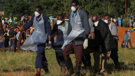 In Simbabwe bringen Polizisten einen Toten weg.