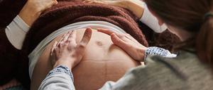 ARCHIV - 17.04.2021, Berlin: Eine Hebamme tastet in ihrer Praxis den Bauch einer schwangeren Frau ab. Mit der Akademisierung der Hebammen-Ausbildung sind die Bewerbungen an den Hochschulen in Nordrhein-Westfalen enorm hoch. (zu dpa "NRW-Verband: Ansturm auf Hebammen-Studiengang") Foto: Annette Riedl/dpa +++ dpa-Bildfunk +++