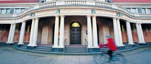 Eine Radlerin passiert das historische Hauptgebäude der Universität Hamburg.