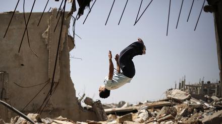 Foto: Afp/ Mohammed Abed Ein junger Palestinenser übt Freerunning in den Ruinen eines Gebäudes