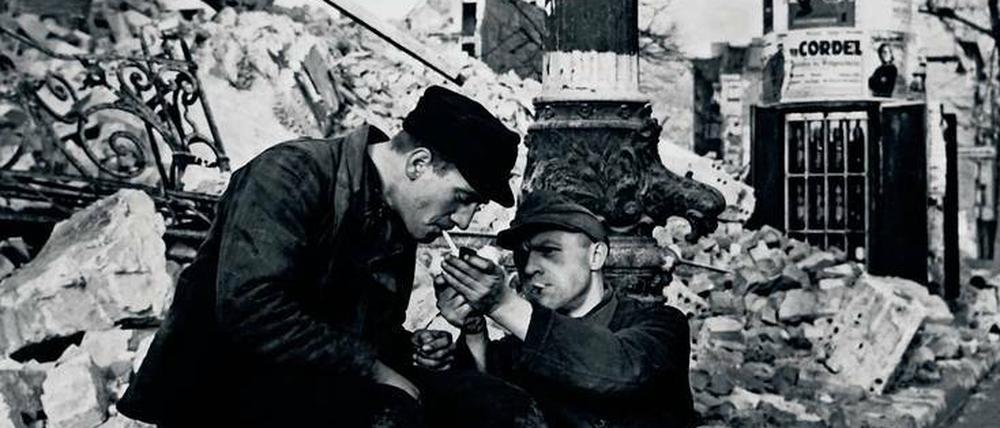 Zwei Männer gönnen sich im Dezember 1948 in den Ruinen Berlins eine Zigarette. Nikotin war damals nicht leicht zu bekommen. 