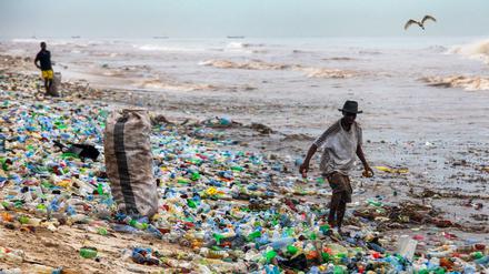 Ein Mann sammelt verwertbares Material am verschmutzten Korle Gono Strand in Ghana.