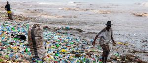 Ein Mann sammelt verwertbares Material am verschmutzten Korle Gono Strand in Ghana.