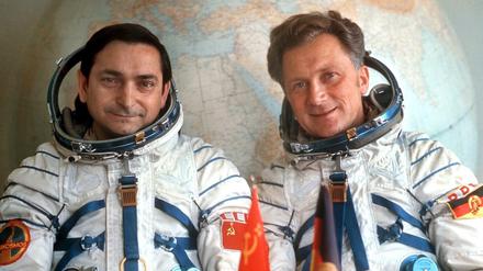 Das Foto vom August 1978 zeigt den sowjetischen Kosmonauten Waleri Bykowski (l) und den DDR-Kosmonauten Sigmund Jähn, die in ihren Raumanzügen vor einem großen Globus im Kosmodrom Baikonur sitzen. 