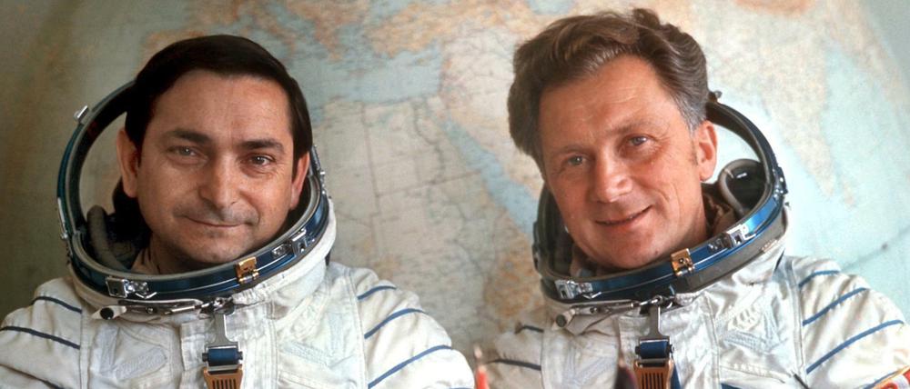 Das Foto vom August 1978 zeigt den sowjetischen Kosmonauten Waleri Bykowski (l) und den DDR-Kosmonauten Sigmund Jähn, die in ihren Raumanzügen vor einem großen Globus im Kosmodrom Baikonur sitzen.