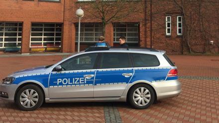 Ein Einsatzfahrzeug der Polizei und Polizeibeamte stehen während eines Einsatzes vor der Eckener Schule.