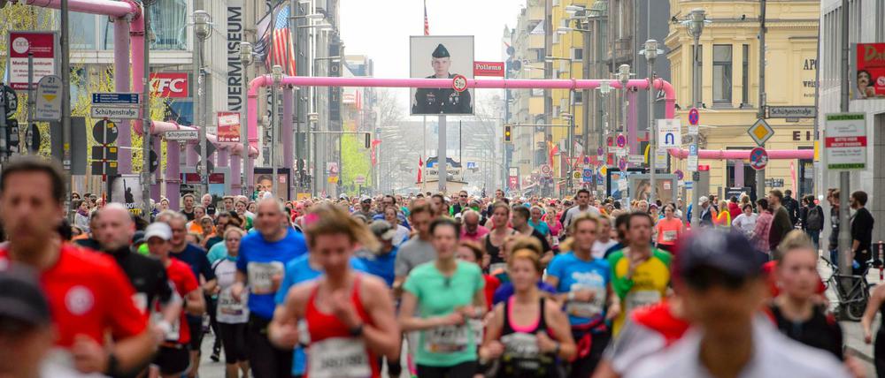Teilnehmer des 37. Halbmarathon in Berlin im Jahr 2017 laufen am Checkpoint Charlie vorbei.