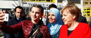 Schülerinnen des Thomas-Mann-Gymnasiums machen Selfies mit Angela Merkel.