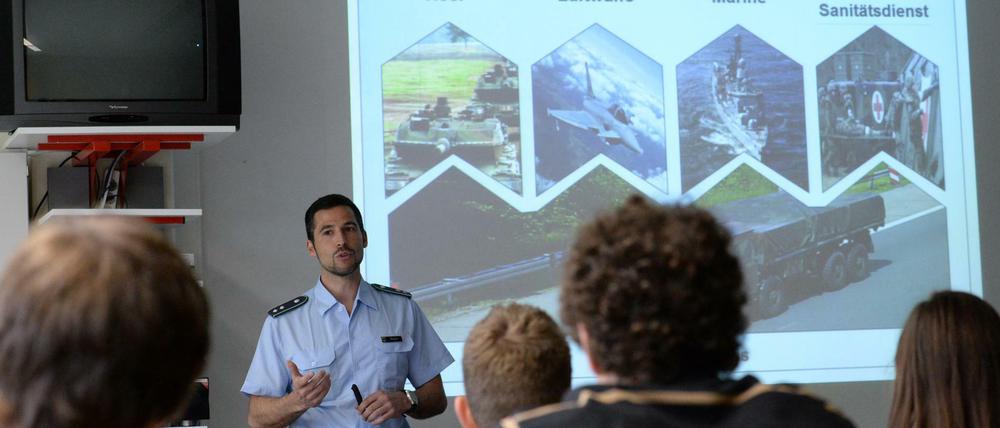 Ein Offizier spricht mit einer Schulklasse.