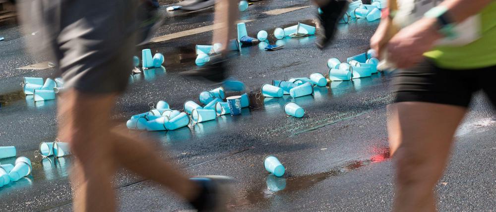 Überall sind weggeworfene Plastikbecher auf dem Asphalt zu sehen.