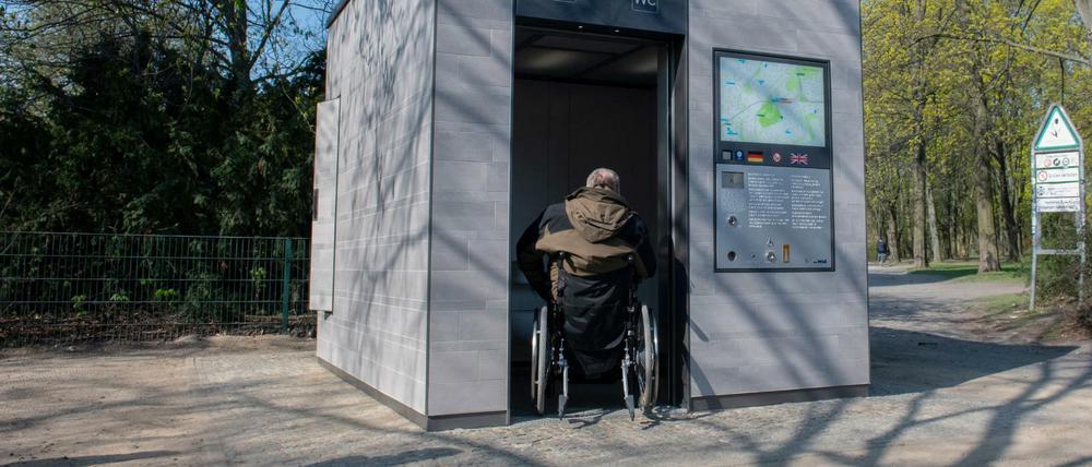Ein Rollstuhlfahrer fährt bei einem Pressetermin an der Gustav-Meyer-Allee/ Brunnenstraße in die erste neue Berliner Toilette. 