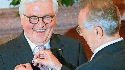 Wie du mir, so ich dir. Dieter Kosslick bekam das Bundesverdienstkreuz, im Gegenzug heftete er dem Bundespräsidenten ein Bärchen ans Revers. Foto: Wolfgang Kumm/dpa