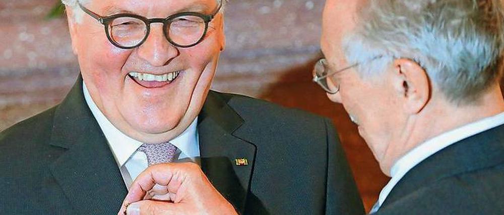 Wie du mir, so ich dir. Dieter Kosslick bekam das Bundesverdienstkreuz, im Gegenzug heftete er dem Bundespräsidenten ein Bärchen ans Revers. Foto: Wolfgang Kumm/dpa