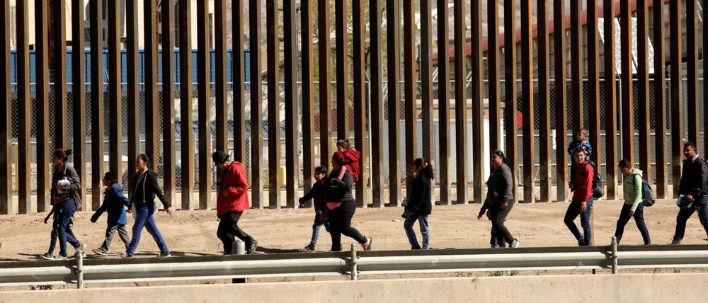 Migranten an der texanisch-amerikanischen Grenze, eskortiert von US-Grenzpersonal.