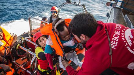 Ein Baby wird in ein Rettungsboot gebracht. 