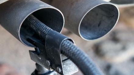 Ein Messschlauch eines Gerätes zur Abgasuntersuchung für Dieselmotoren steckt im Auspuffrohr eines Autos.