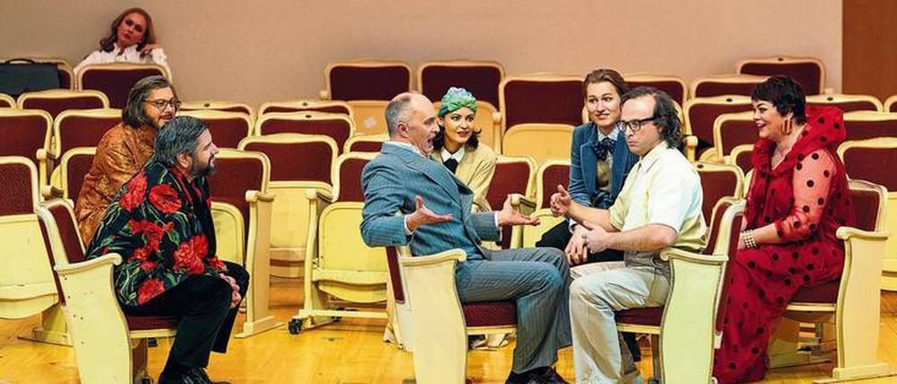 Theaterflair. Regisseur Dmitri Tcherniakov ist auch sein eigener Bühnenbildner. Er verwandelt das Kloster in einen Probenraum mit Zuschauergestühl: Szene mit Stephan Rügamer als Don Jerome (im graublauen Anzug). Außerdem (v.l.): Aida Garifullina, Lauri Vasar, Goran Jurić, Anna Goryachova, Bogdan Volkov, Andrey Zhilikhovsky und Violeta Urmana.