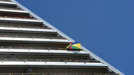 Ein bunter Sonnenschirm in der oberen Etage eines Wohnhochhauses in Berlin.