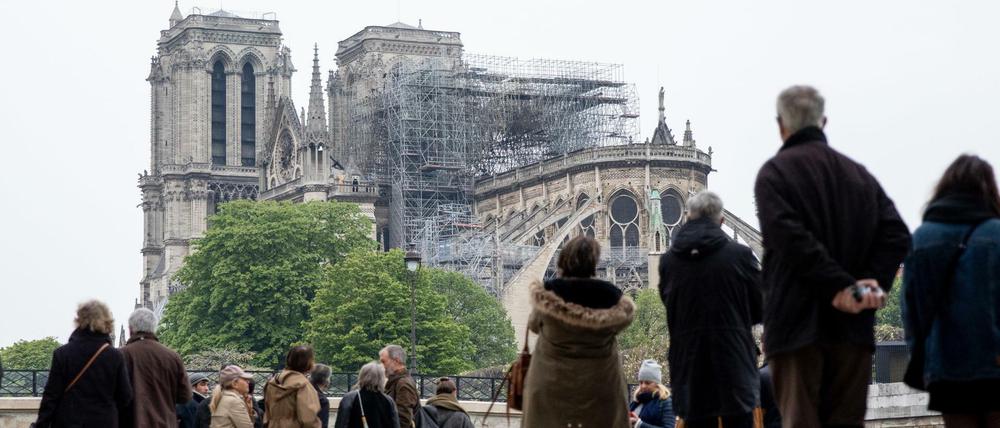 Menschen kommen am Dienstag zur Kathedrale, halten inne.