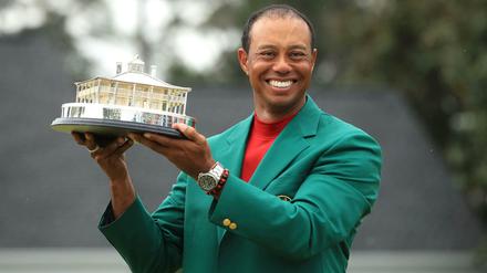 Gute Laune: Golfprofi Tiger Woods präsentiert im grünen Siegerjackett die Trophäe der Masters.