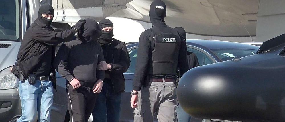 Ein mutmaßliches Mitglied der Terrormiliz IS wird auf dem Flughafen Hamburg zu einem Hubschrauber der Bundespolizei gebracht.