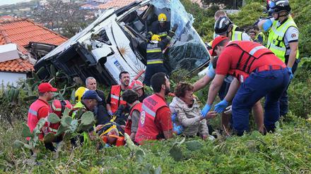 Feuerwehrleute befreien Passagiere aus dem Unglücksbus in Madeira. ARD und ZDF reagierten am Donnerstag mit Sondersendungen auf das Unglück, das 29 Menschen das Leben kostete, darunter wohl hauptsächlich deutsche Touristen.
