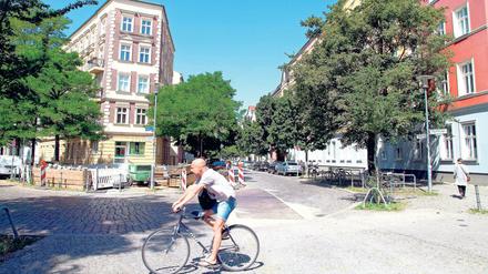 Sommerlich gekleideter Radfahrer vor Altbaukulisse im Kaskelkiez in Berlin-Lichtenberg.
