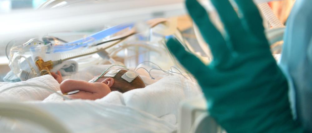 Ein Baby liegt in der Neonatologie in einem Inkubator.