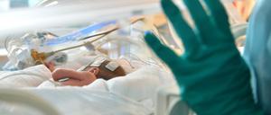 Ein Baby liegt in der Neonatologie in einem Inkubator. 