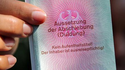 Eine junge Frau hält einen Ausweis für Flüchtlinge in der Hand.