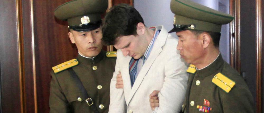 Der US-Bürger Otto Warmbier (M) wird am 16.03.2016 in einem Gericht in Pjöngjang (Nordkorea) von zwei nordkoreanischen Polizisten eskortiert.