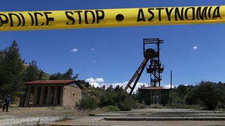 Ein Polizist (l) steht in der Nähe des überfluteten Minenschachts, wo zwei weibliche Leichen gefunden wurden.