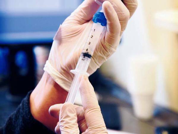 Eine Mitarbeiterin in Peschels Praxis zieht eine Spritze mit Diamorphin-Lösung auf.