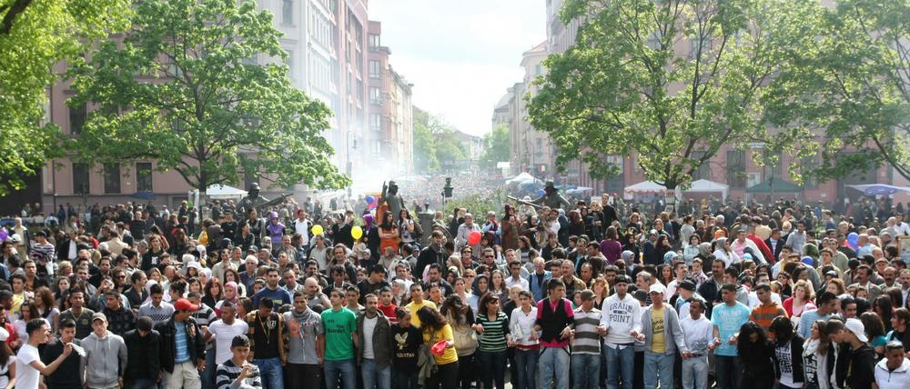 Mehrere tausend Menschen feiern und tanzen am Mariannenplatz in Berlin während eines bunten Straßenfestes.