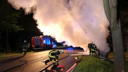 Feuerwehrleute löschten das brennende Auto.