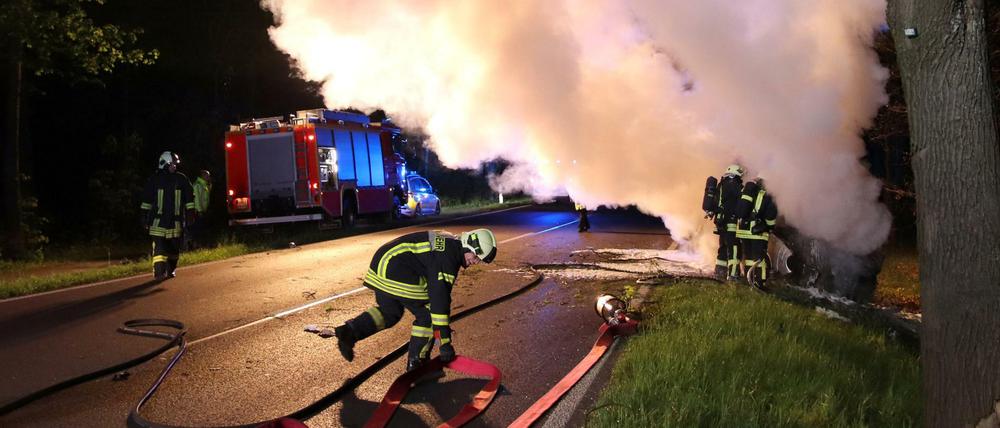 Feuerwehrleute löschten das brennende Auto.