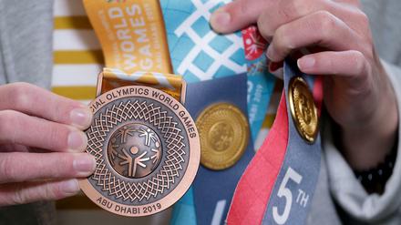 Eine Teilnehmerin der Special Olympics in Abu Dhabi zeigt ihre Medaille. 2023 sollen die Spiele in Berlin stattfinden. 