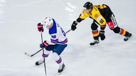 US-Superstar Patrick Kane schirmt den Puck vor Patrick Hager ab.
