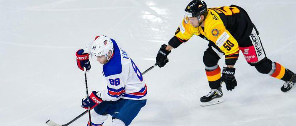 US-Superstar Patrick Kane schirmt den Puck vor Patrick Hager ab.