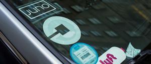 Ein Auto mit Aufklebern verschiedener Fahrdienste in den USA an der Windschutzscheibe.