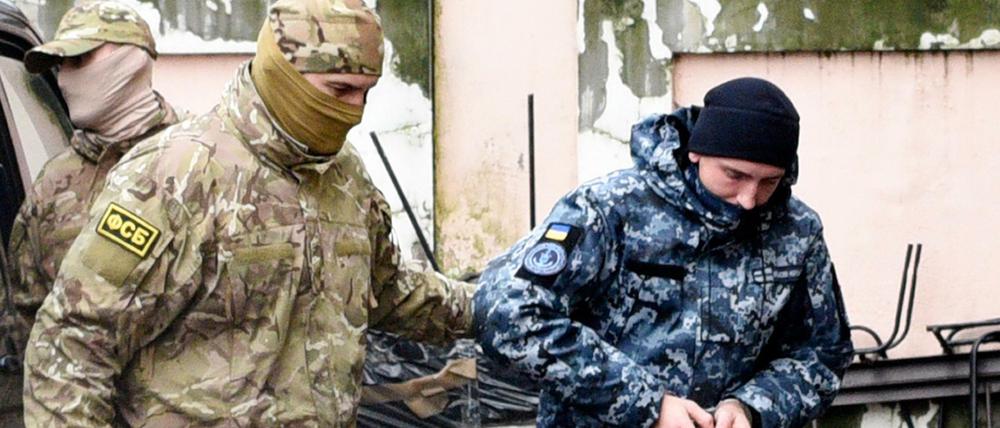 Nach der Festnahme im November 2018 führt ein Offizier des russischen Geheimdienstes FSB (links) einen ukrainischen Marinesoldaten ab.