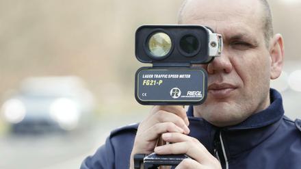 Polizist mit Tempomessgerät.