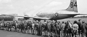 Kinder stehen 1949 auf dem Flughafen Berlin-Tempelhof und sehen der Landung eines US-amerikanischen Transportflugzeuges zu. 